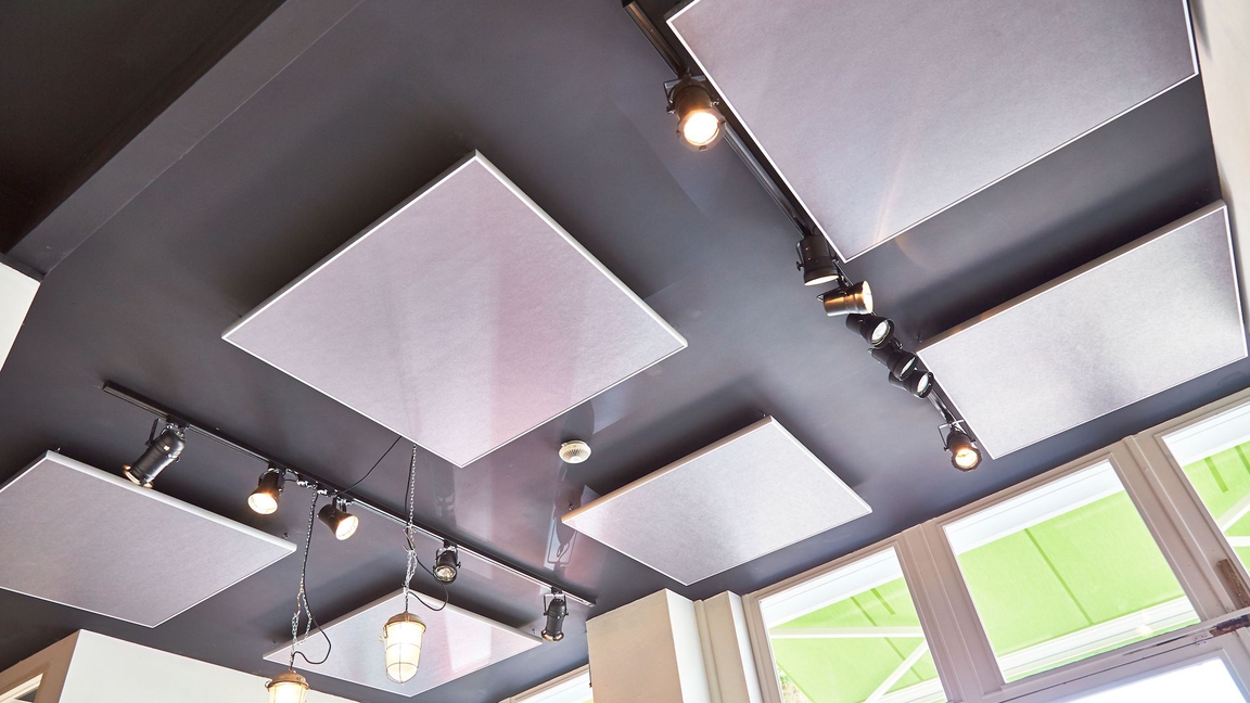 De akoestische plafondpanelen met industrial design passen in het interieur