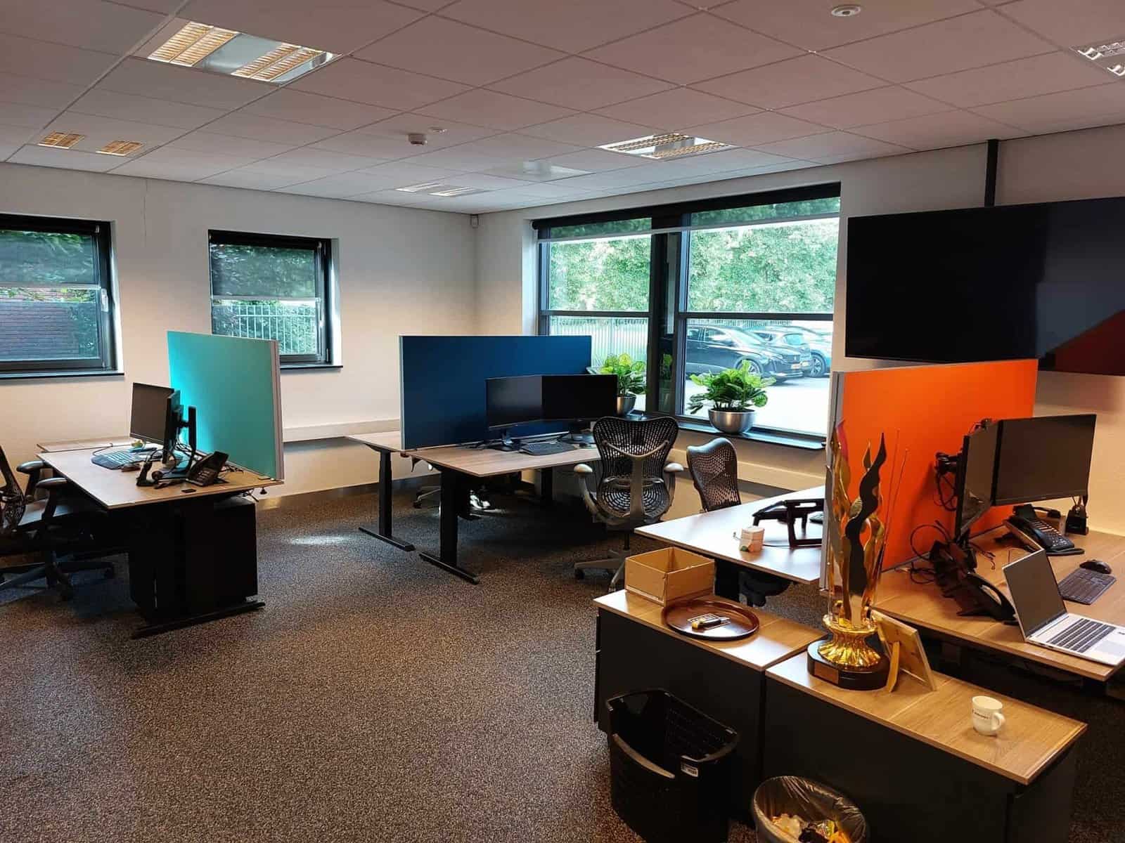 Rustig kantoor met akoestische scheidingswanden en meerdere werkplekken, ideaal voor een geconcentreerde werkomgeving.